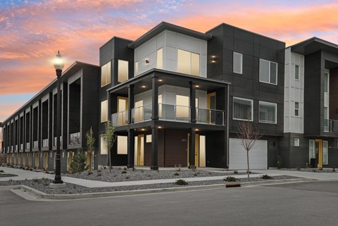 A modern apartment building with black and white exterior and yellow accents.