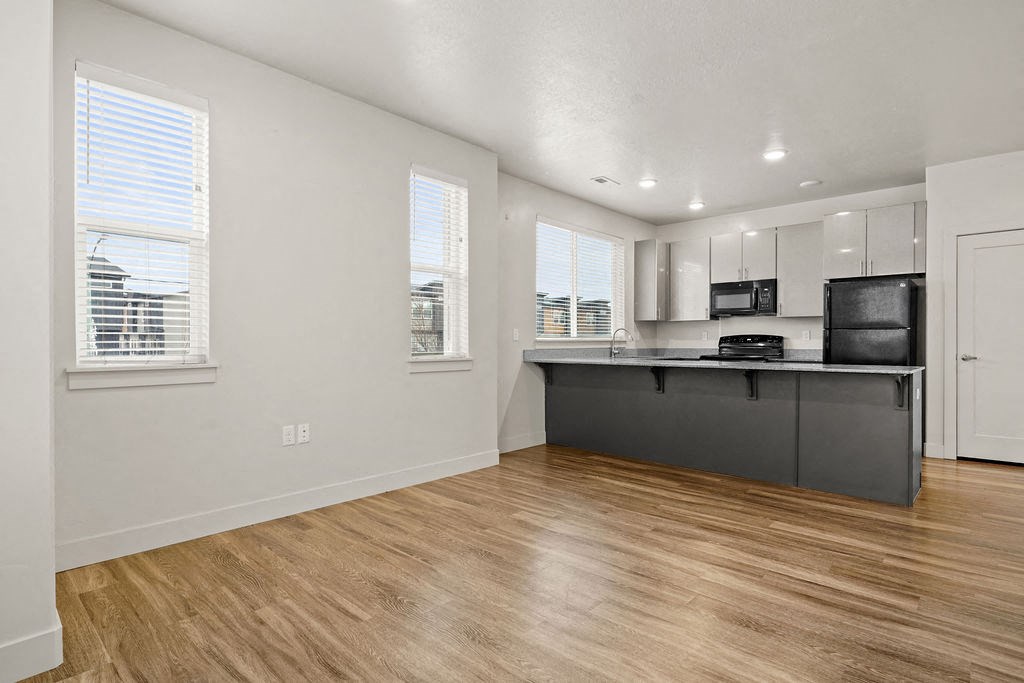 A kitchen with a wooden floor and white walls.