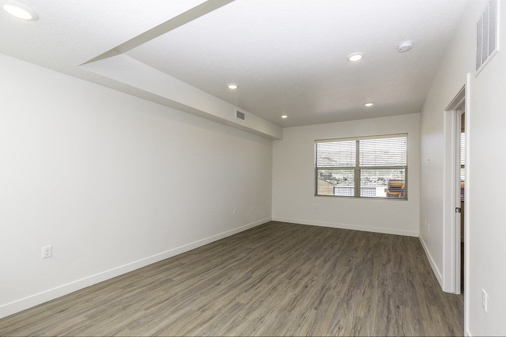 an empty living room with white walls and a window