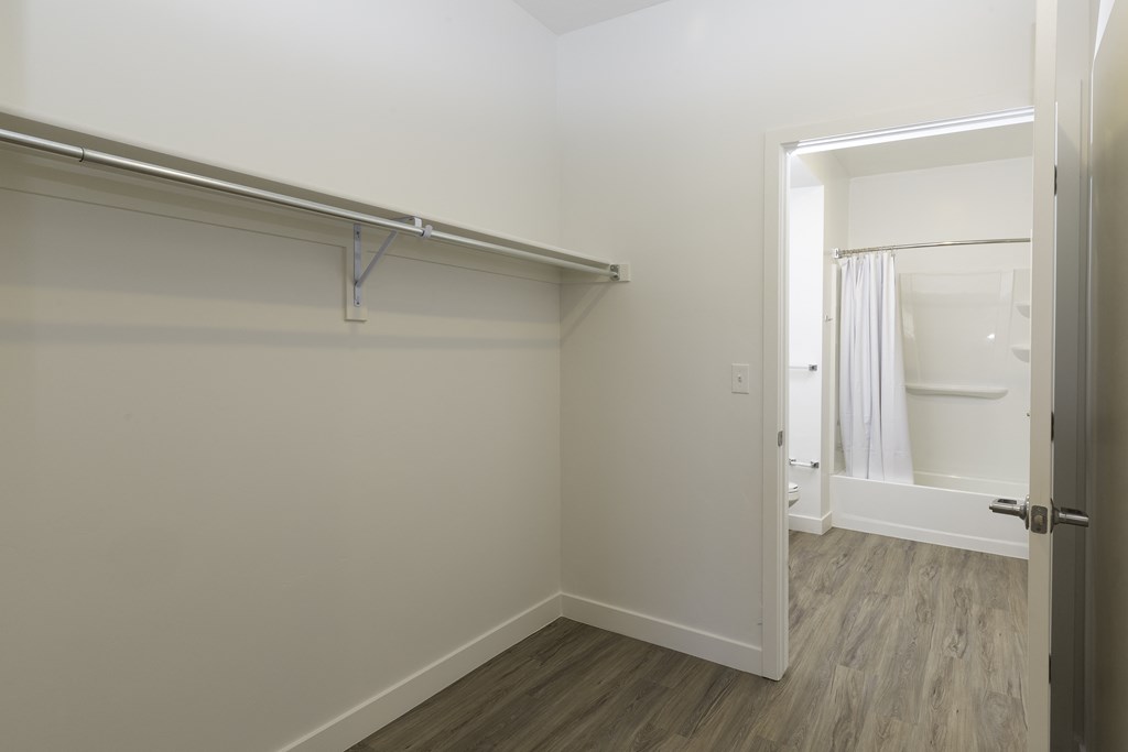 an empty room with a closet and a door to a bathroom