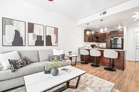 A modern living room with a grey couch and a white coffee table.
