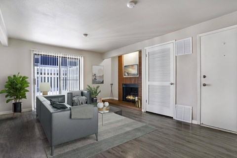 A living room with a grey couch and a fireplace.