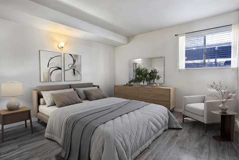 A bedroom with a large bed, a nightstand, and a chair.