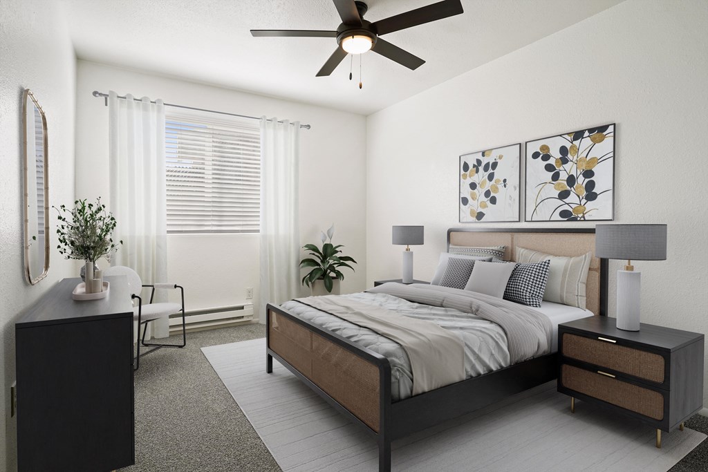 A modern bedroom with a large bed, a ceiling fan, and a side table with a lamp.