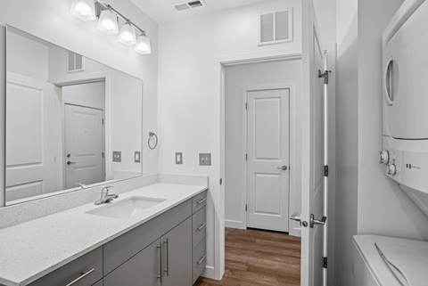 A bathroom with a sink, mirror, and toilet.