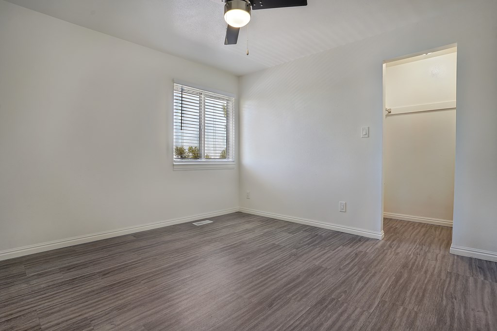 A room with a window and a wooden floor.