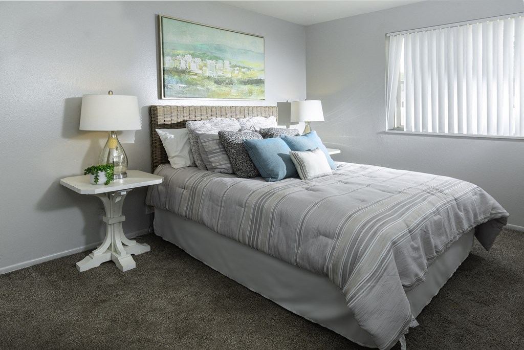 a bedroom with a bed and a night stand with two lamps