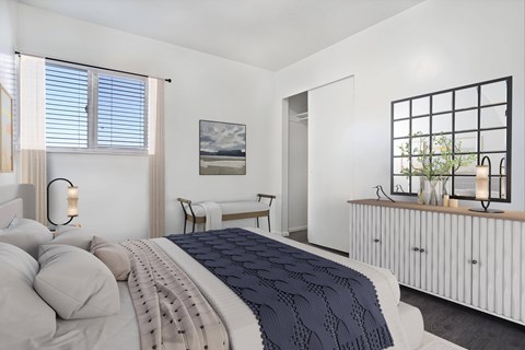 A bedroom with a large bed and a painting on the wall.