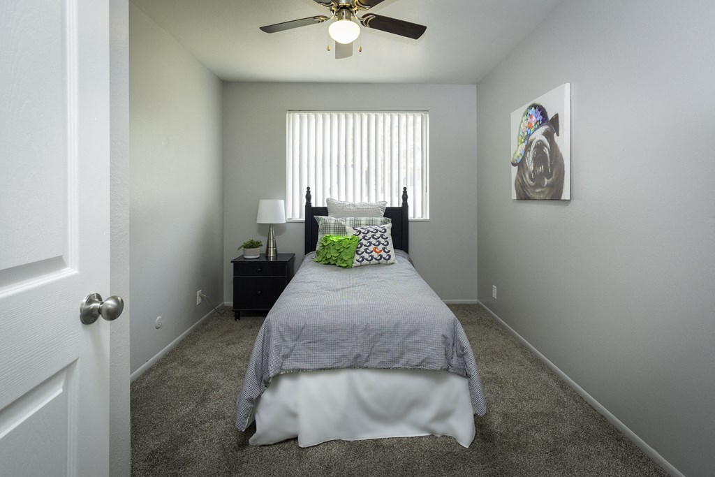 a bedroom with a bed and a ceiling fan