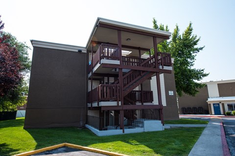 A brown building with a balcony and a red line on the ground.