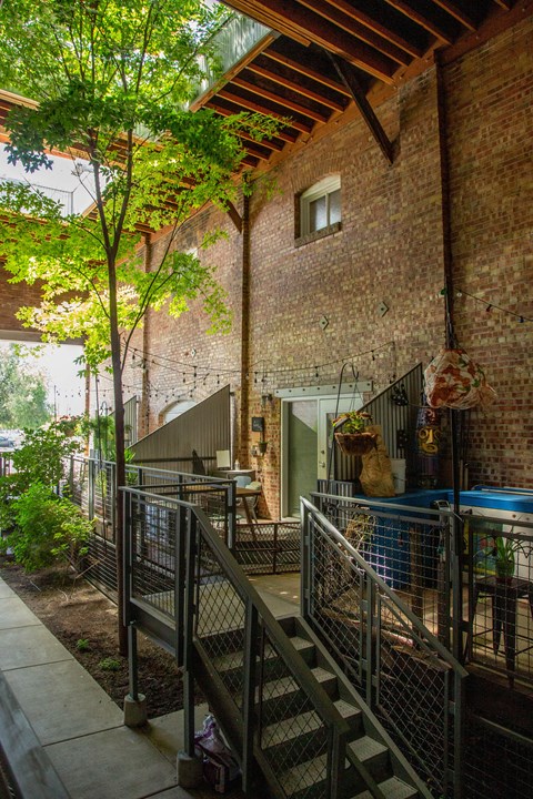 the back yard of a brick house with trees and a deck