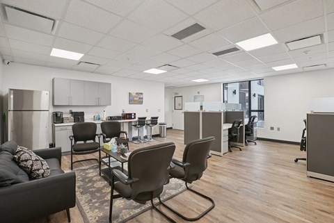 A modern office space with a couch, chairs, and a coffee table.