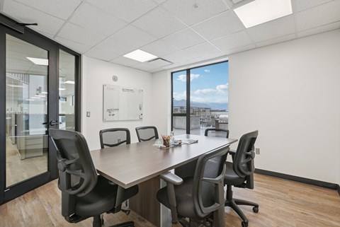 A conference room with a long table and chairs.