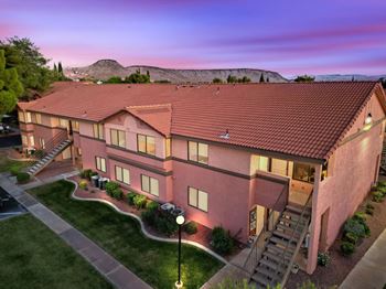 A building with a red tiled roof and a staircase leading to the entrance.