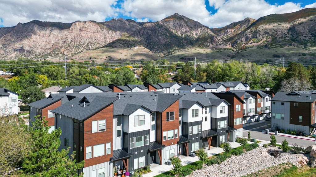 an aerial view of a row of houses with mountains in the background