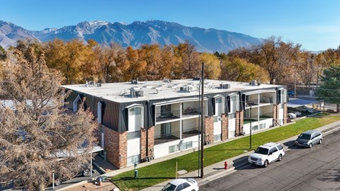 A modern building with a parking lot in front of it.