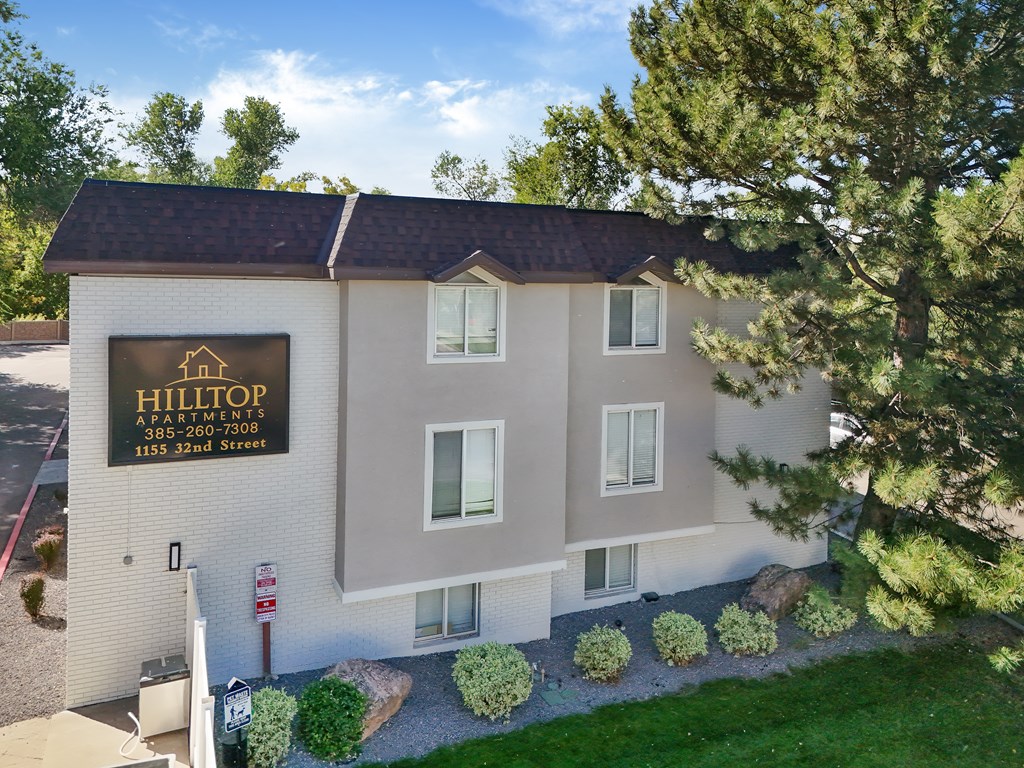A building with a sign that says Hilltop Apartments.
