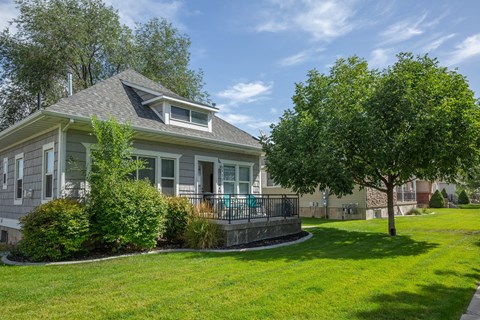 a house with a large lawn and trees in front of it