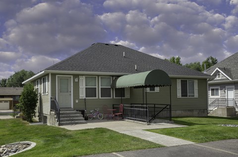a house with awning in front of a yard