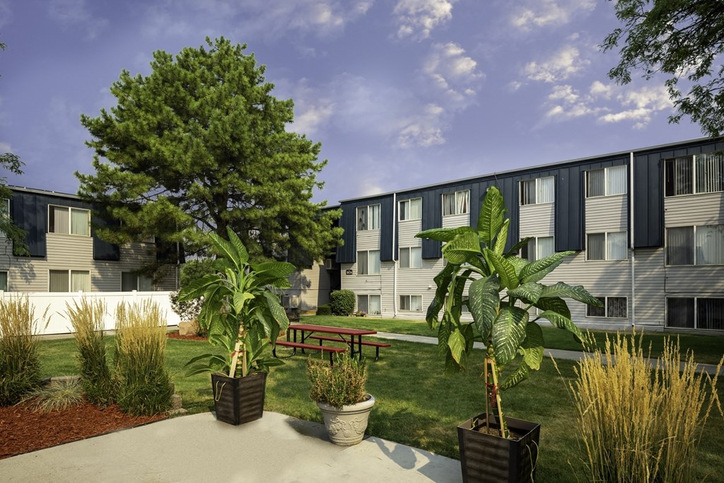 an exterior view of an apartment building with a patio and potted plants