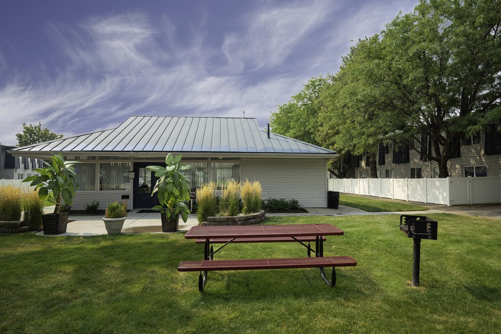 a picnic table in a yard in front of a house