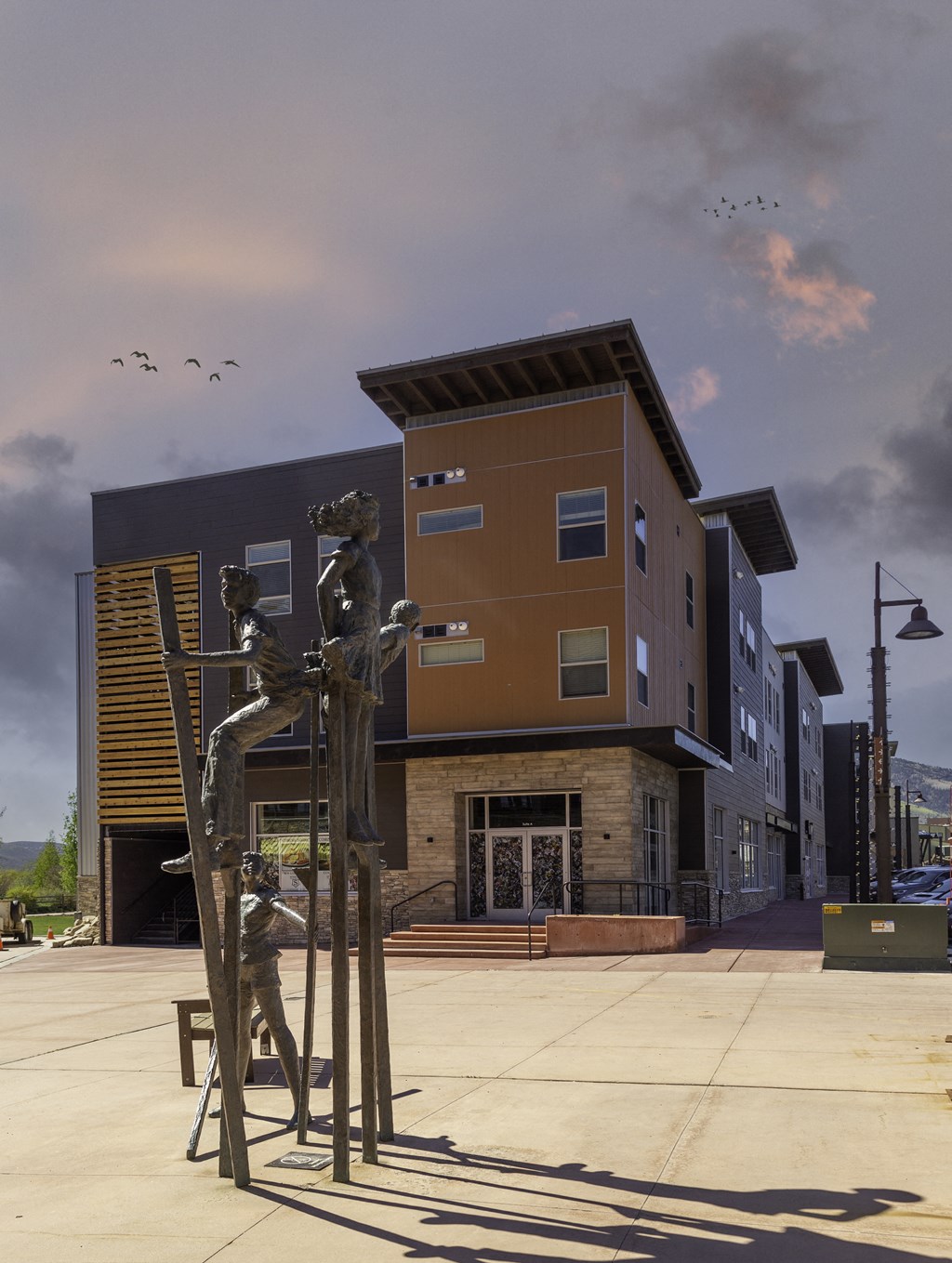 a sculpture of two people sitting on a chair in front of a building
