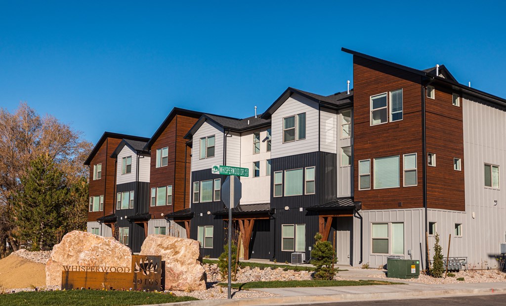 a row of townhomes on a sunny day with a blue sky