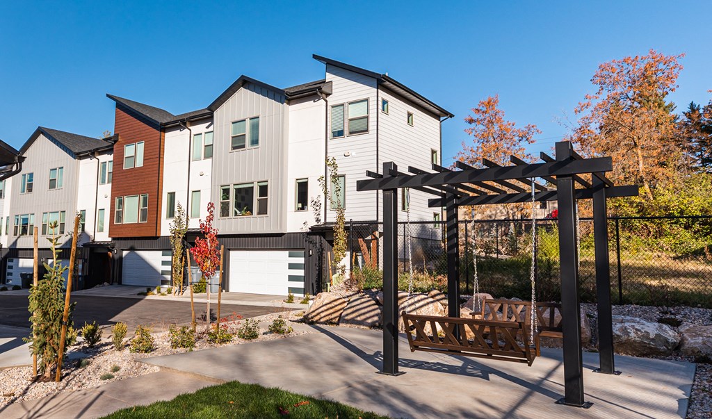 a view of a row of houses with a wooden pergola in the foreground