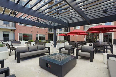 A patio with a fire pit and seating area.