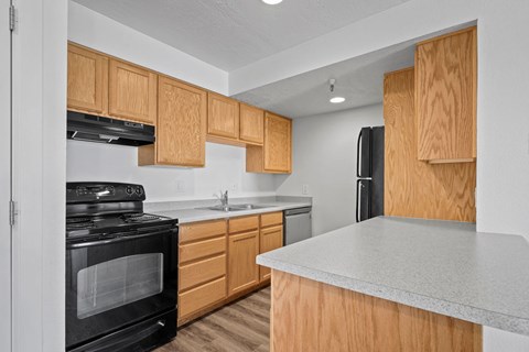 A kitchen with wooden cabinets and a black stove top oven.