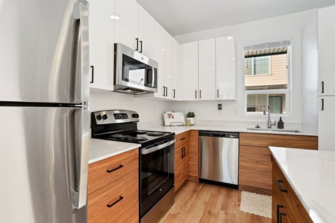 an updated kitchen with stainless steel appliances and white cabinets