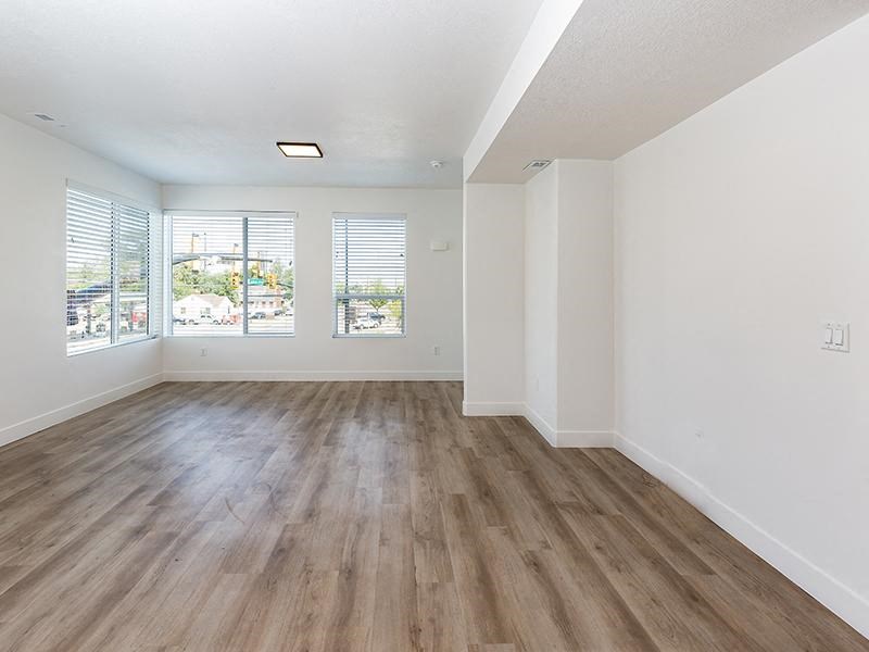 an empty living room with white walls and wood floors