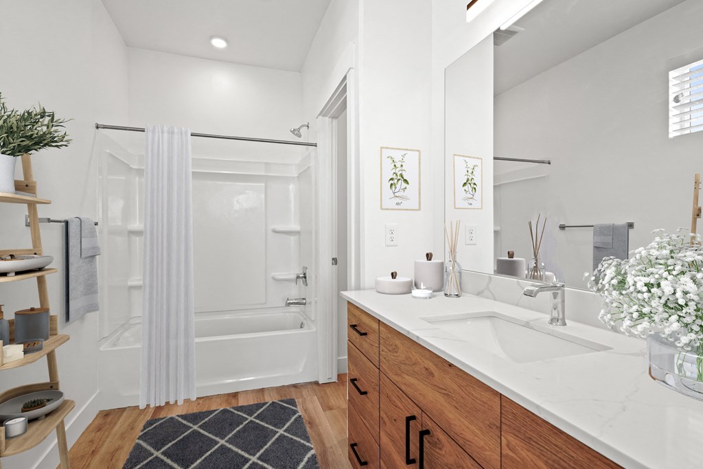 a white bathroom with a sink and a shower
