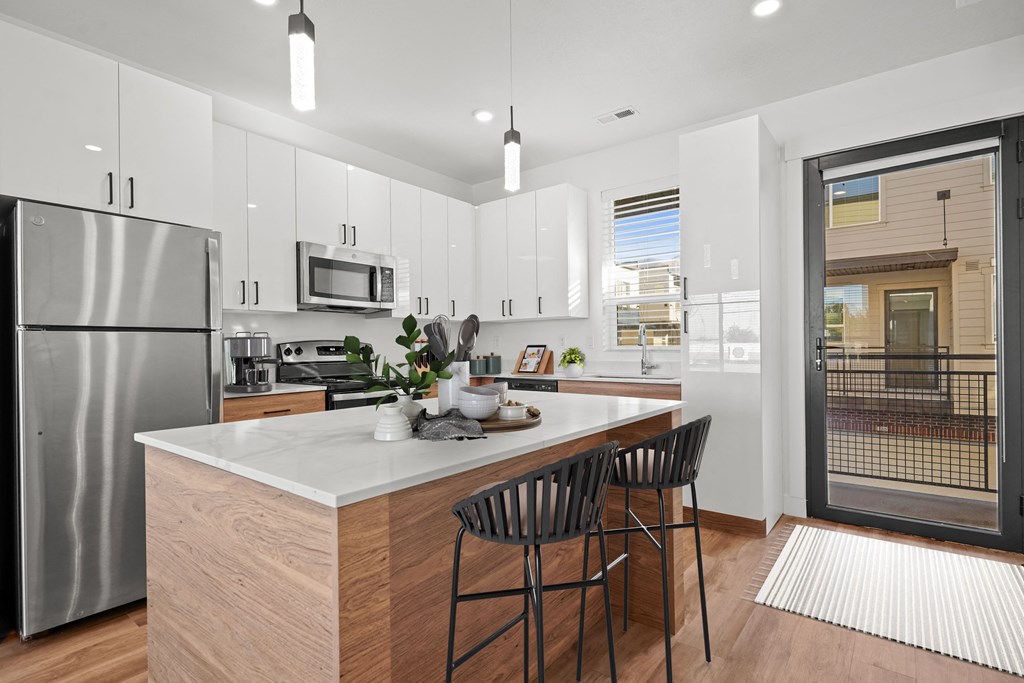 an open kitchen with a large island with two stools