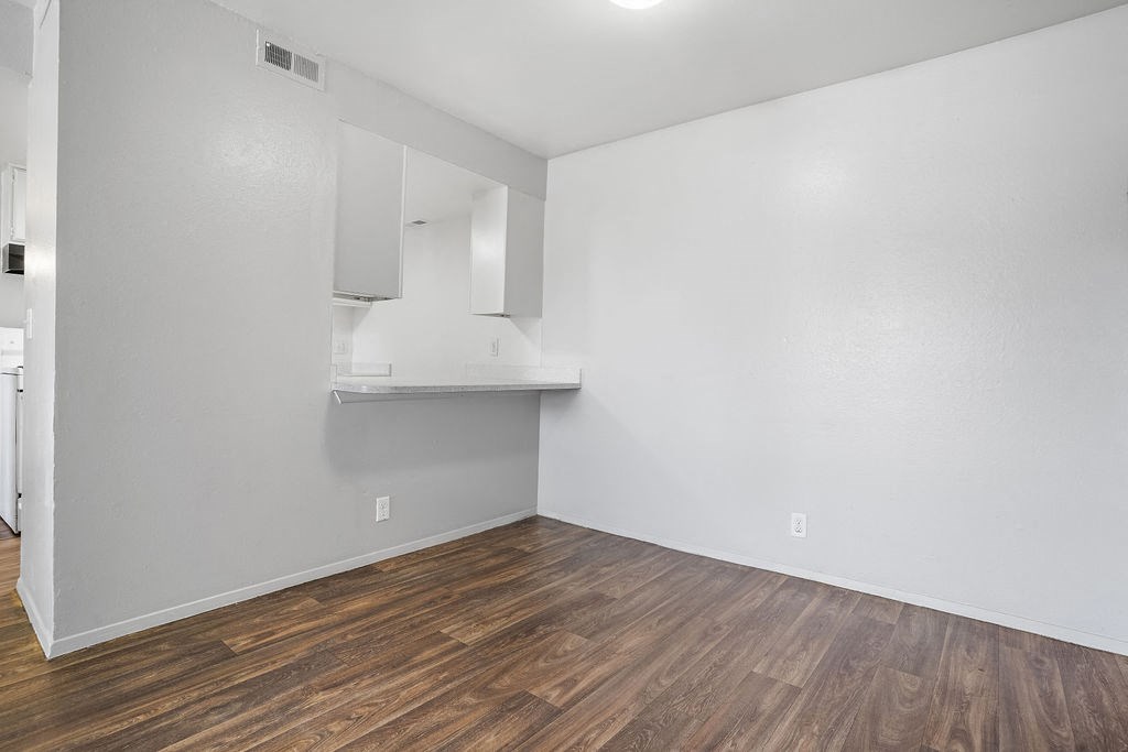 an empty living room with white walls and wood floors