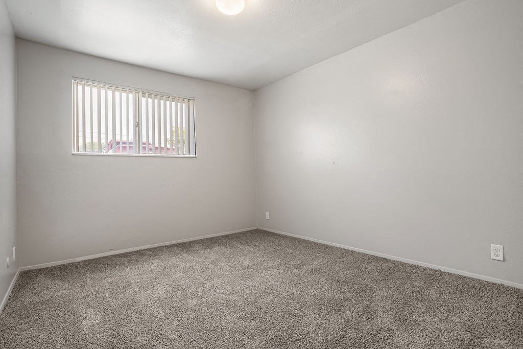 an empty room with carpet and a window