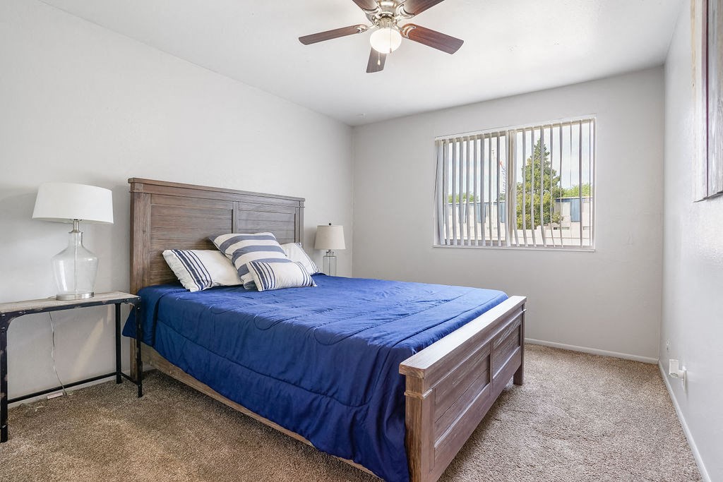 a bedroom with a bed and a ceiling fan