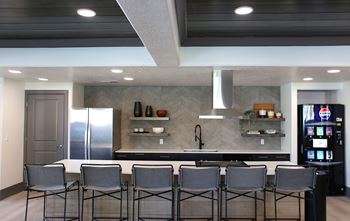 A kitchen with a bar area and four chairs.