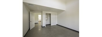 A large empty room with white walls and a grey floor.