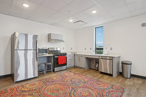 A kitchen with a refrigerator, stove, and sink.