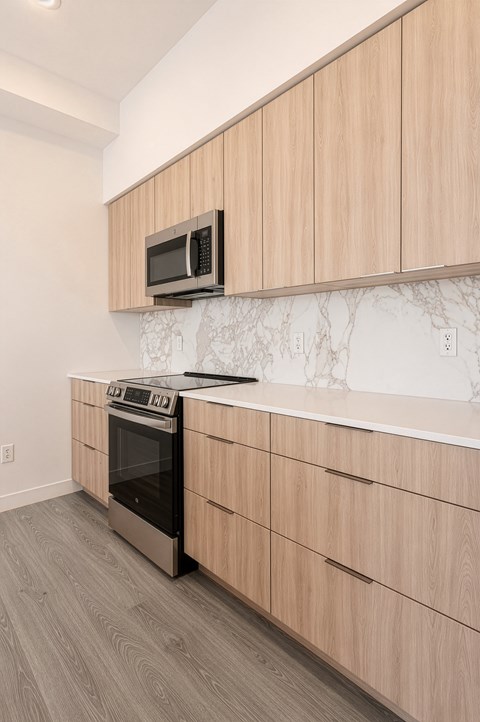 A kitchen with wooden cabinets and a black stove top oven.