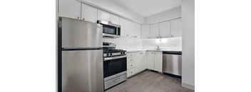 A modern kitchen with stainless steel appliances and white cabinets.