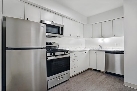 A modern kitchen with stainless steel appliances and white cabinets.