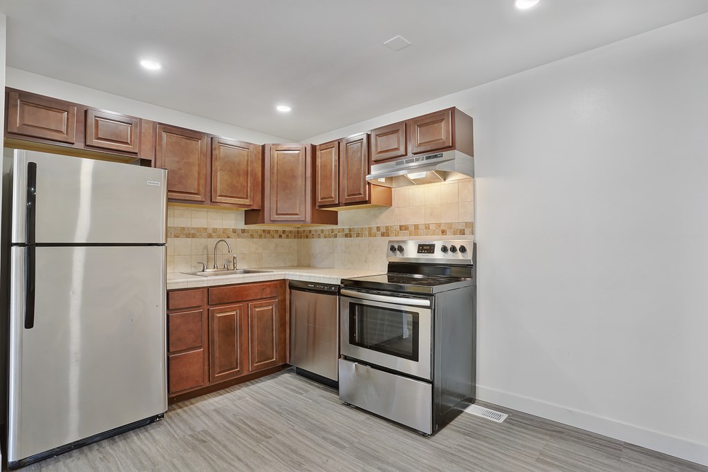 A kitchen with a stainless steel refrigerator, oven, and microwave.