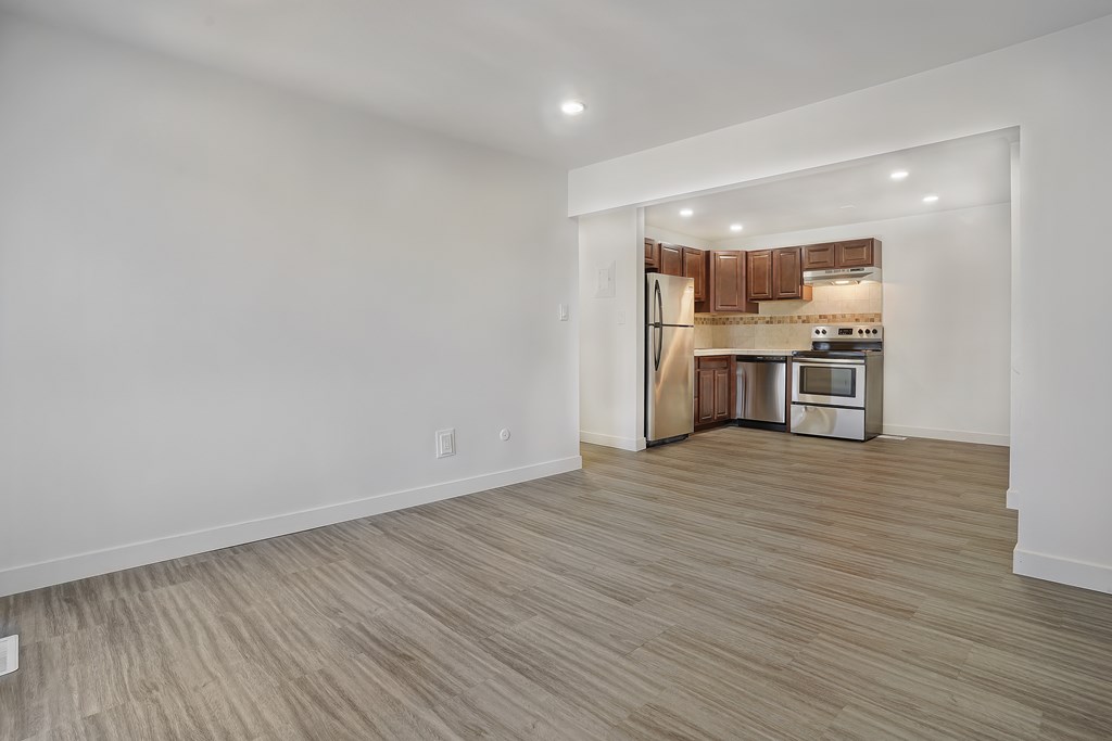 A kitchen area with wooden flooring and white walls.