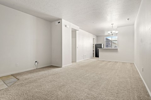 A spacious room with a carpeted floor and white walls.