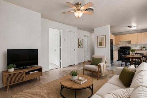 A living room with a white couch, a coffee table, and a flat screen TV.