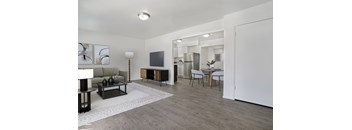 A modern living room with a white sofa, a black coffee table, and a TV.