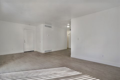 A large empty room with a door and a window.
