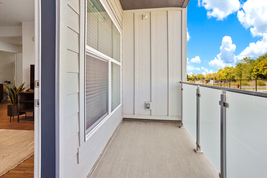 a balcony with a view of a blue sky and some trees